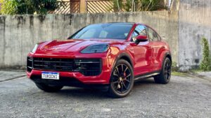 Porsche Cayenne GTS Coupé 2026 vermelho, vista frontal em estrada asfaltada, destacando faróis e entradas de ar, orientação horizontal