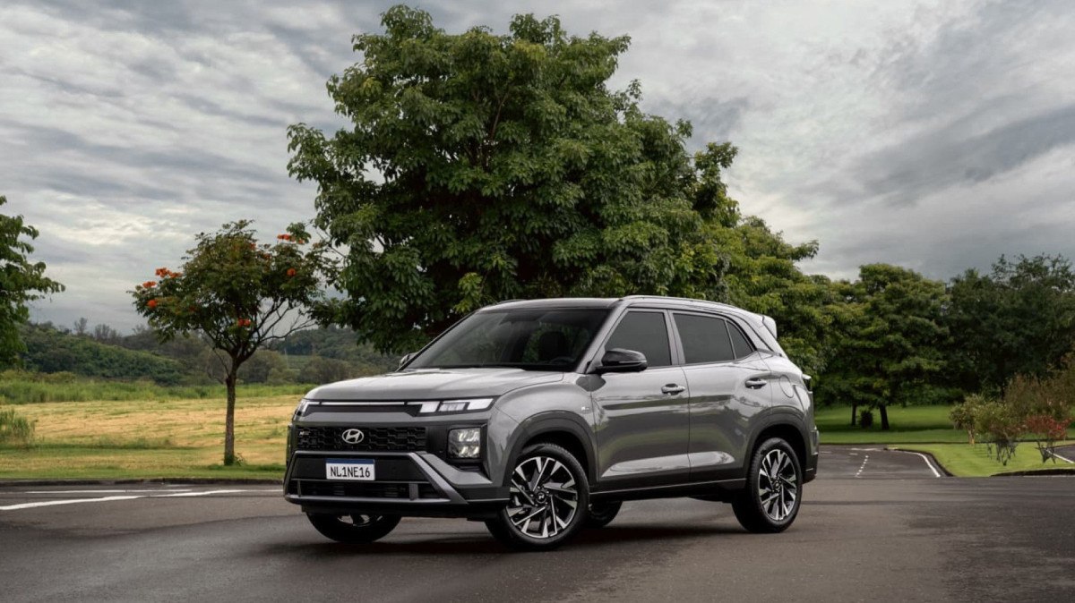 Creta lidera buscas de 0 km: O que explica a virada? Toyota Yaris Cross 2026 em frente a uma concessionária brasileira, foto lateral horizontal landscape