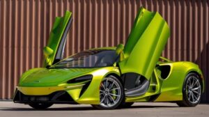 McLaren e Aston Martin estreiam em Interlagos com carros de milhões McLaren e Aston Martin expostas lado a lado no Autódromo de Interlagos, vista frontal horizontal, ambiente de evento automotivo premium