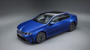 Novo BMW i3 inaugura virada elétrica com corte de 10% Novo BMW i3 elétrico camuflado ou em versão de produção, visto de frente na fábrica de Munique, orientação horizontal