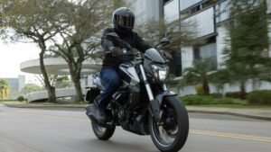 Bajaj Dominar 250 2026/2027 na cor Racing Red, foto frontal em avenida urbana brasileira, orientação horizontal landscape