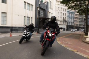 Bajaj bate recorde e já ameaça sair do nicho no Brasil Motociclistas observando uma Bajaj Pulsar N150 e uma Dominar em concessionária brasileira, vista horizontal