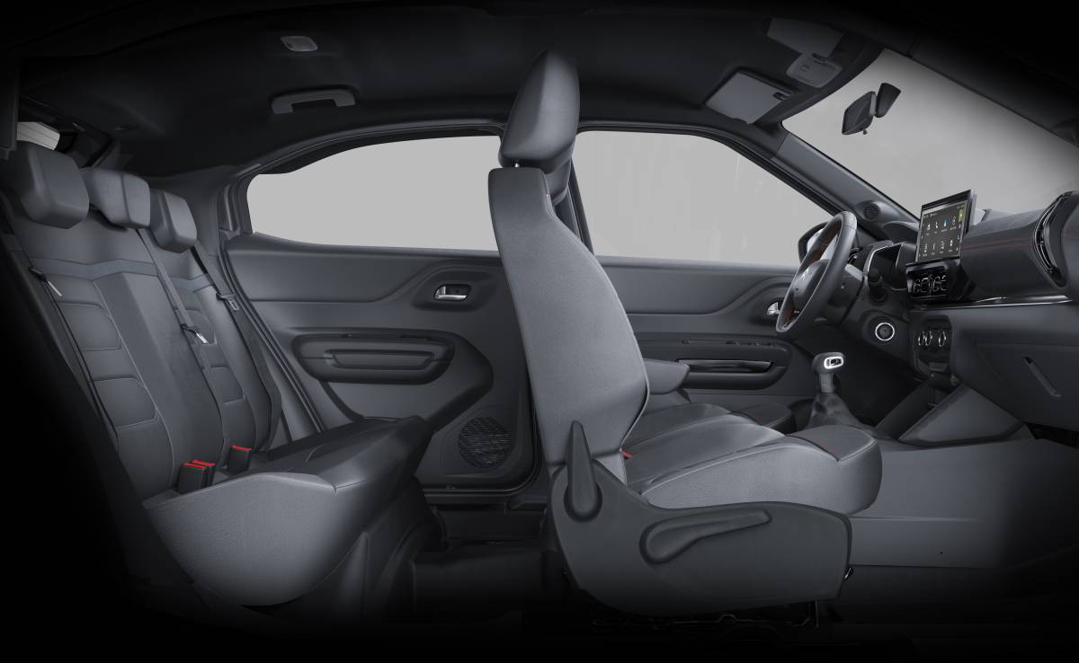 Citroën Basalt 2027: Preços partem de R$ 95.590 Interior de um carro com bancos cinza escuro, volante e painel com tela multimídia. O banco do motorista está rebatido para frente, mostrando o espaço traseiro com três encostos de cabeça e cintos de segurança. As portas têm acabamento escuro e detalhes em relevo. A iluminação é suave, destacando os assentos e o console central.