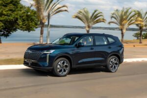 Suspensão revista e 126 km de autonomia no H6 híbrido GWM Haval H6 PHEV35 2027 na cor azul, vista frontal em uma avenida brasileira, fotografia horizontal landscape