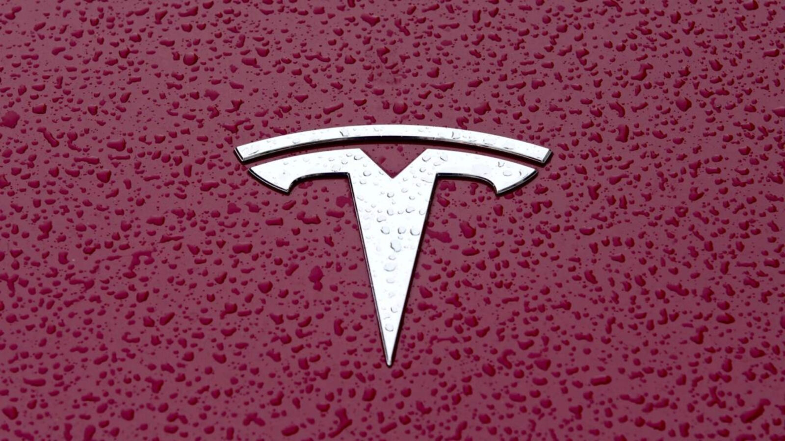Tesla Model 3 e Tesla Model Y em vista frontal, estacionados diante de um centro de atendimento na China, orientação horizontal