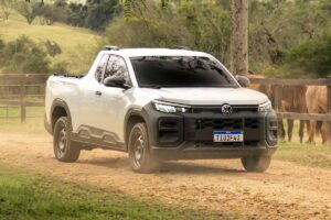 Volkswagen Tukan Robust mira briga com a Fiat Strada Endurance Volkswagen Tukan Robust projetada como picape compacta de cabine simples, vista frontal em estrada rural brasileira, para-choque robusto e caçamba vazia, orientação horizontal landscape