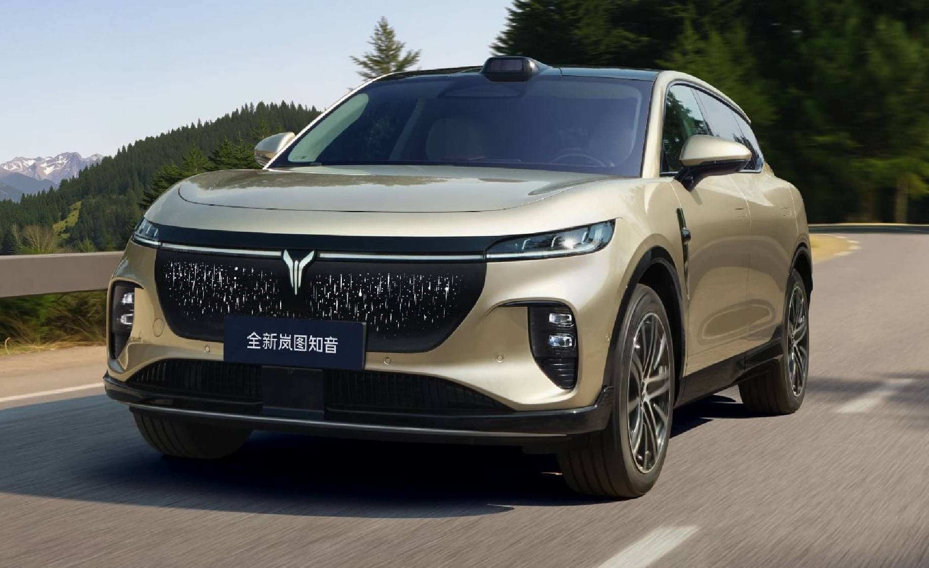 Voyah no Brasil: Quatro modelos e até 1.530 km SUV dourado em movimento numa estrada sinuosa, com montanhas e árvores verdes ao fundo. O carro tem uma grade frontal preta com um emblema prateado e um sensor preto no teto. Na placa frontal, lê-se 全新岚图知音