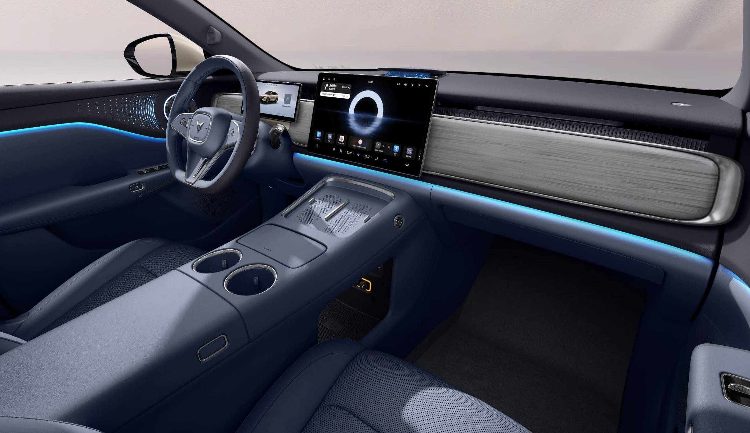 Voyah no Brasil: Quatro modelos e até 1.530 km Interior de carro moderno com bancos e console central em azul-marinho, volante escuro e tela multimídia grande no painel. Detalhes em madeira clara e iluminação ambiente azul neon atravessam o painel e as portas, criando um design futurista