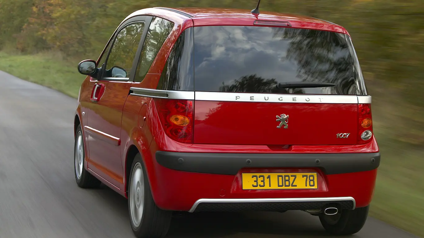 Peugeot 1007: 1.291 kg e portas elétricas de van Peugeot 1007 vermelho em movimento de traseira