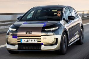 Audi A2 e-tron pode virar o elétrico mais barato? Audi A2 e-tron em foto frontal horizontal, carro cinza em estrada europeia destacando o desenho aerodinâmico do hatch