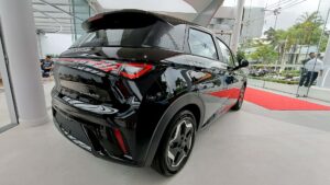 Carros elétricos lideram o varejo no Brasil em 2026? BYD Dolphin GS em foto lateral rodando em avenida urbana, com destaque para o porte de hatch elétrico, landscape