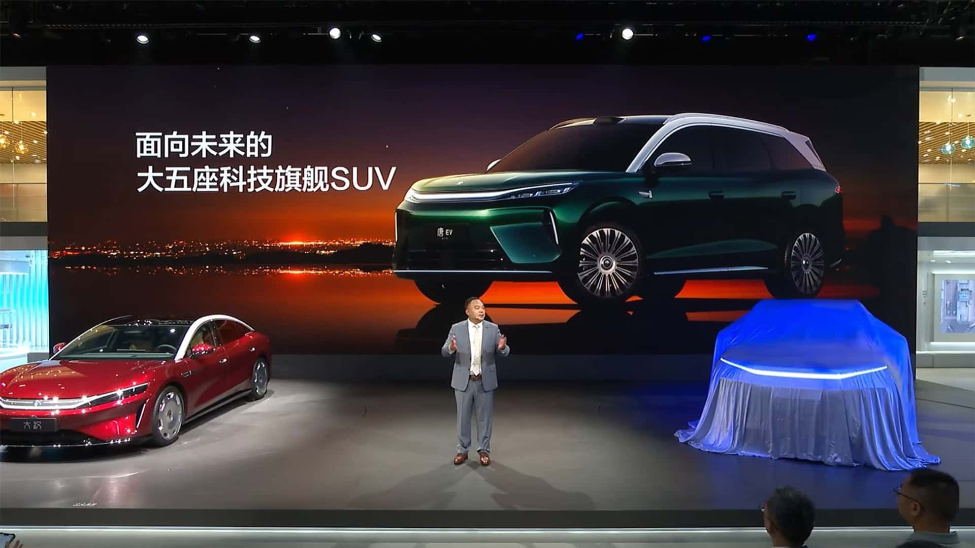 BYD Tan estreia grande porte com 850 km e cinco lugares BYD Tan atual vendido no Brasil em vista lateral, mostrando o SUV de sete lugares estacionado diante de uma concessionária, orientação horizontal landscape