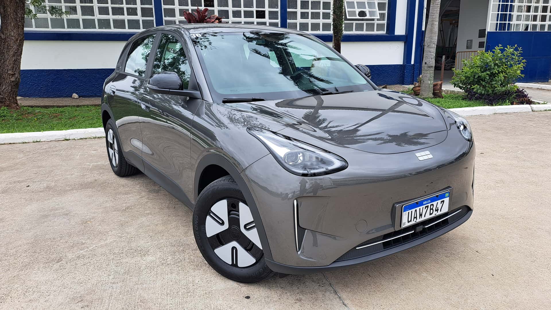 Carros elétricos lideram o varejo no Brasil em 2026? Volkswagen Tera e Hyundai Creta estacionados ao lado de um BYD Dolphin Mini em concessionária, comparação horizontal