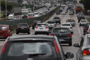 Carro com campanha pode mudar a cobertura do seguro carro particular brasileiro com adesivo eleitoral discreto na lateral, estacionado em rua urbana, fotografia horizontal landscape