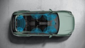 Porsche GaN: Som Burmester de 400 watts chega em 2027 Amplificador automotivo Burmester com tecnologia de nitreto de gálio, componentes eletrônicos e dissipador de calor em bancada, imagem horizontal