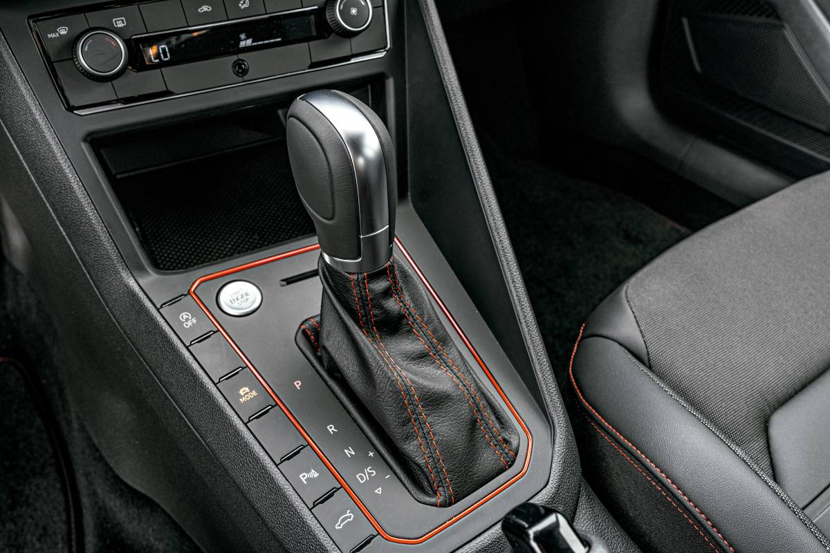 motorista selecionando D em um câmbio automático, painel do carro aceso e interior em orientação horizontal, landscape