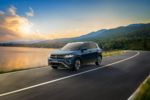 Volkswagen T-Cross 2027 em foto frontal três quartos na cor cinza, rodando em avenida urbana, landscape