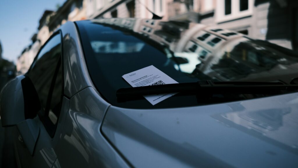 Licenciamento MG: prazo por placa, taxa e CRLV digital Notificação presa no para-brisa de carro estacionado, risco de quem circula sem licenciamento